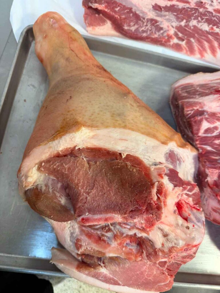 Raw fresh ham roast showing the uncured hind leg cut.