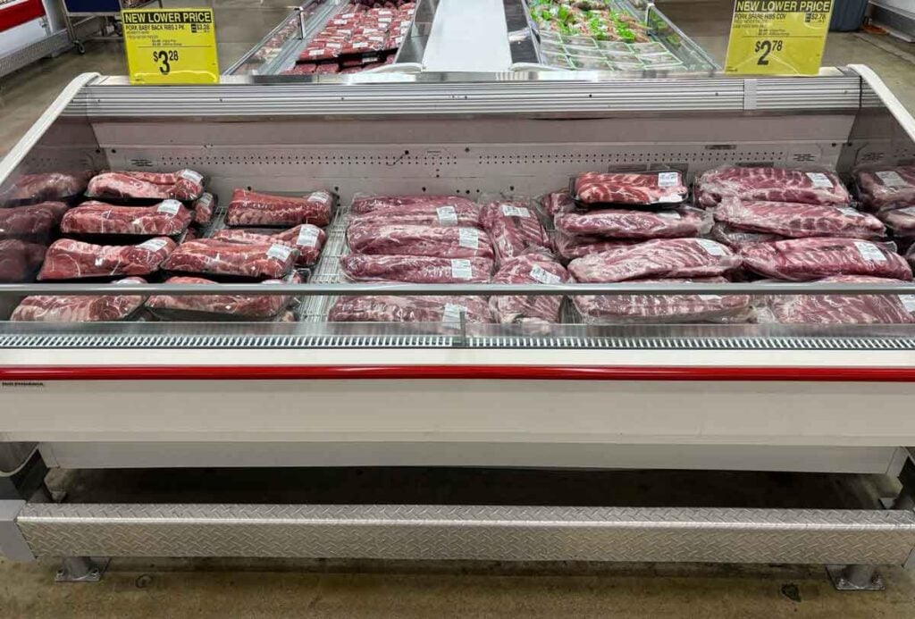 Packaged baby back ribs and spare ribs in a Sam&rsquo;s Club meat case, showing how shoppers compare different rib cuts in the store.