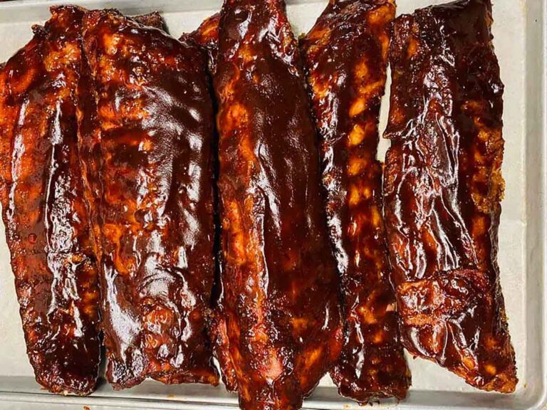 Sauced ribs finished in a shallow pan after reheating for a make-ahead rib dinner.