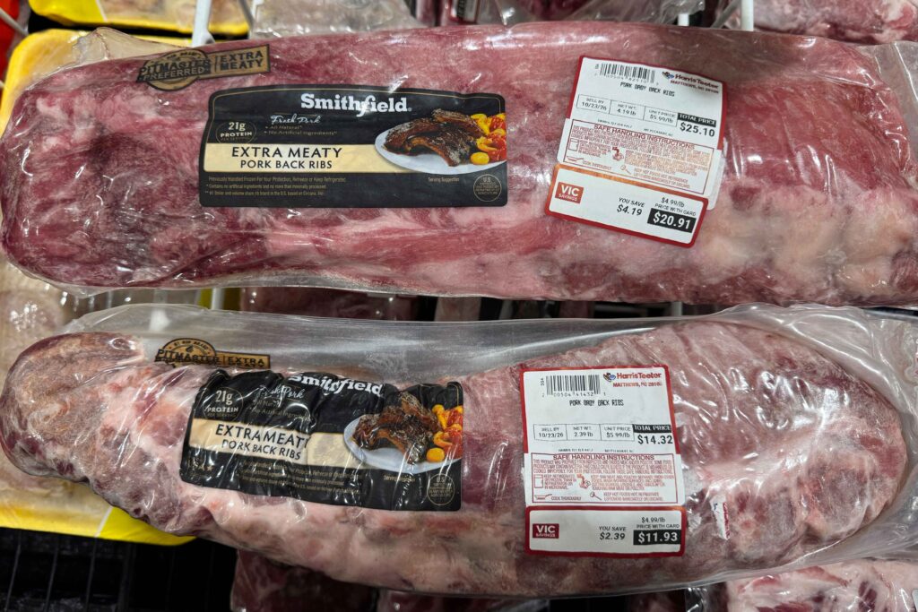Two packages of pork back ribs with different weights, showing why rack size matters when buying ribs for a crowd.