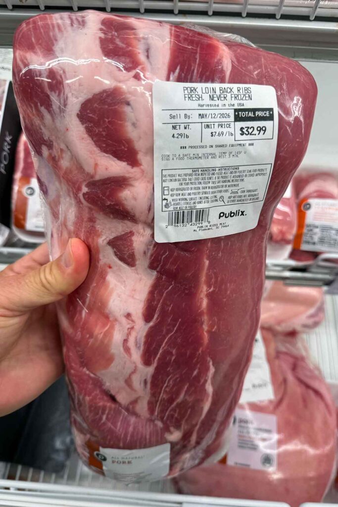 Pork loin back ribs package label showing the cut name, weight, price, and fresh-never-frozen note.