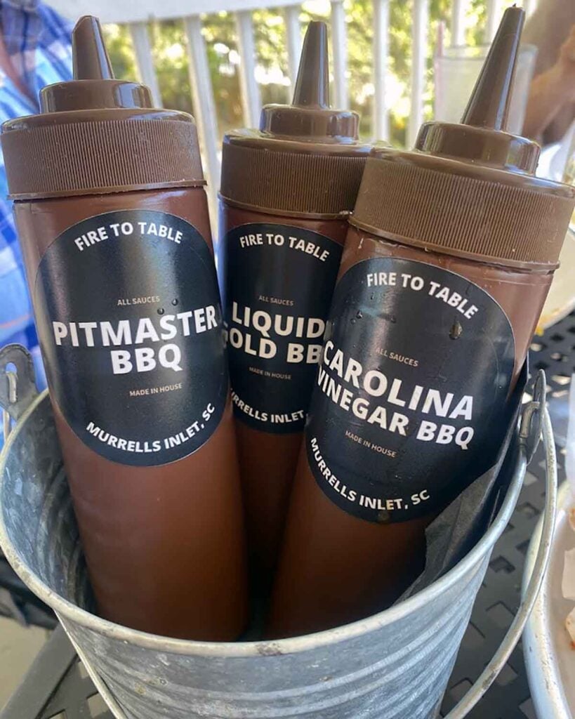 Barbecue sauces offered by Fire to Table in bucket on table. 