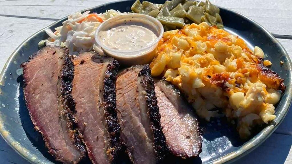 Brisket plate with mac and cheese, slaw and green beans with sauce on the side.