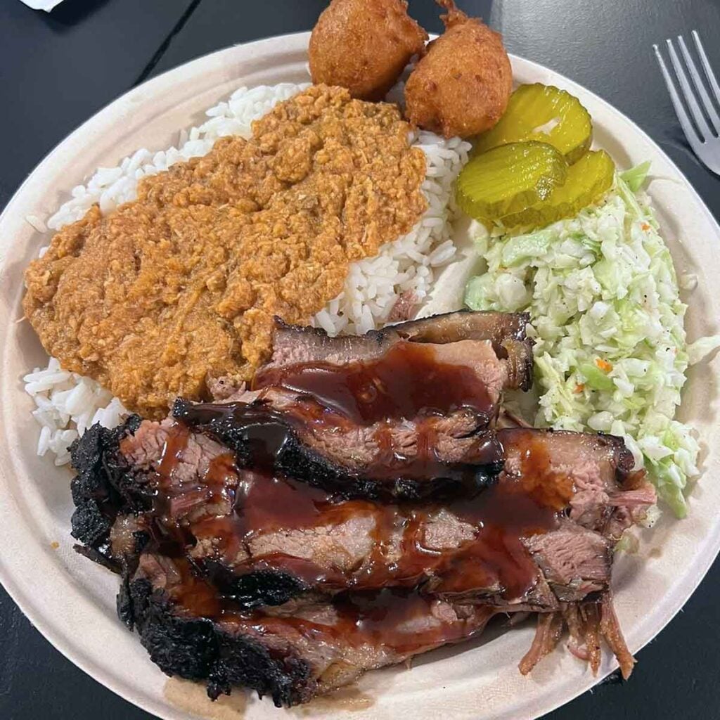 Brisket plate with hash, slaw, pickles, and hush puppies.