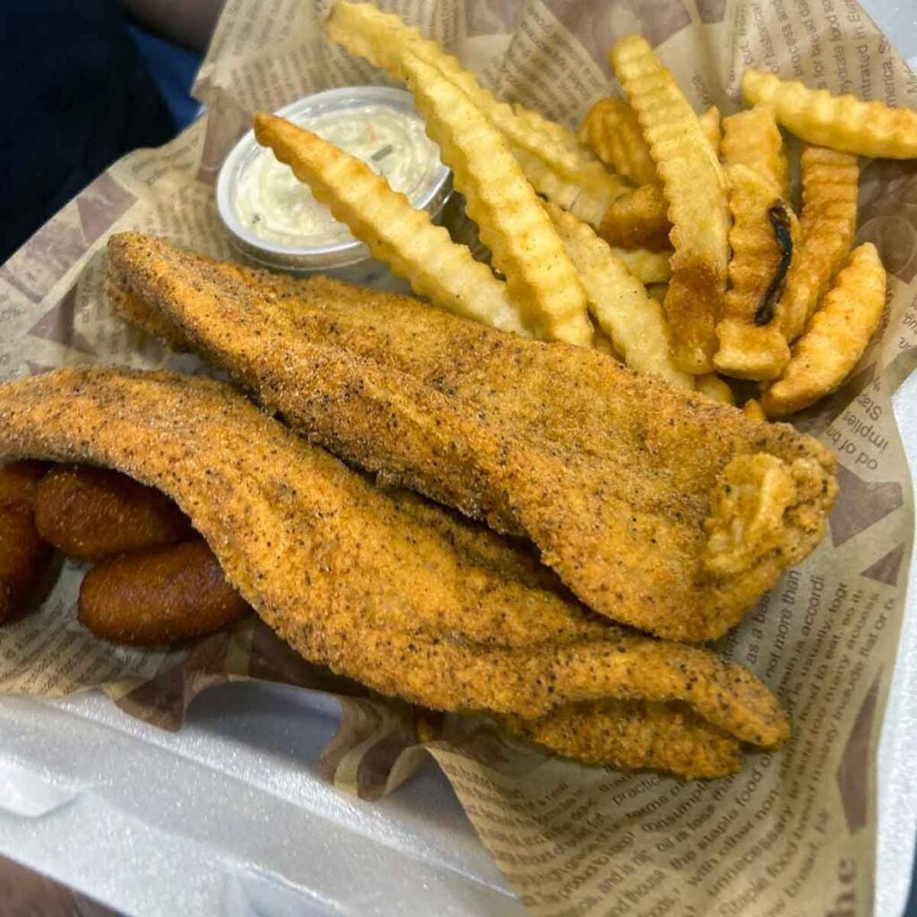 Fried fish, fries and slaw in basket.