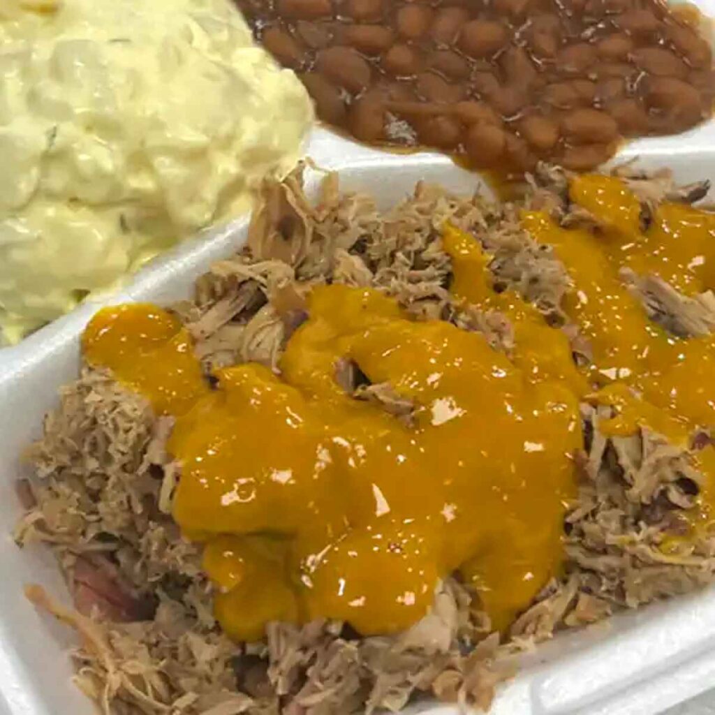 Pulled pork with mustard BBQ sauce, potato salad, and baked beans.