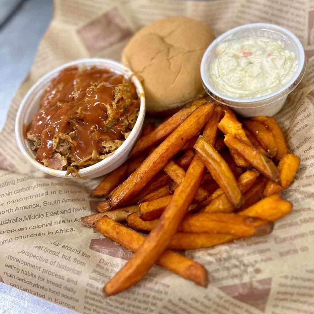 Pulled pork sandwich basket with slaw and sweet potato fries.