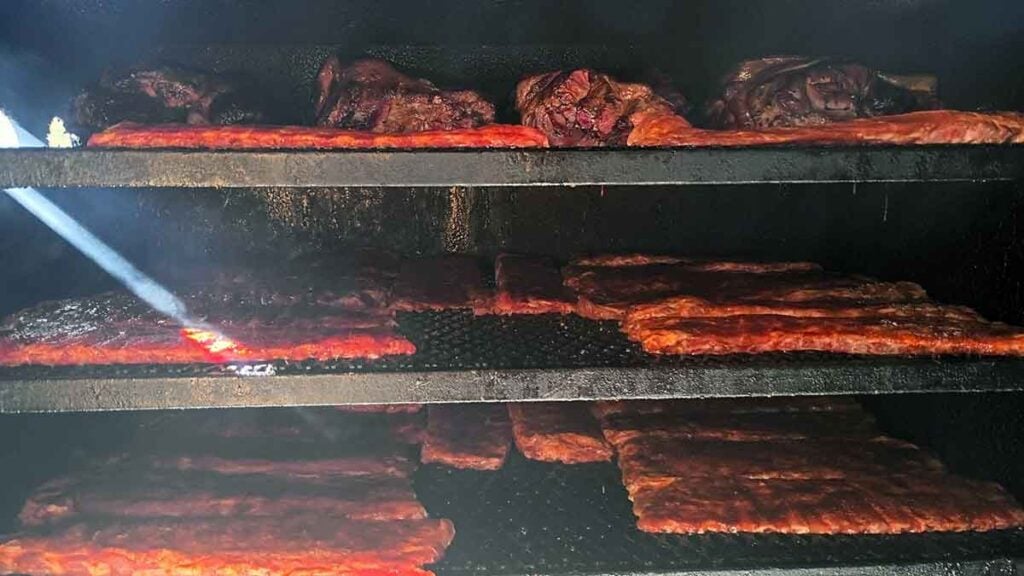 Ribs on racks rotating in the smoker.