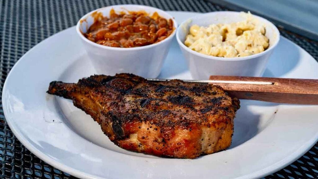 Grilled steak with baked beans and Mac and cheese.