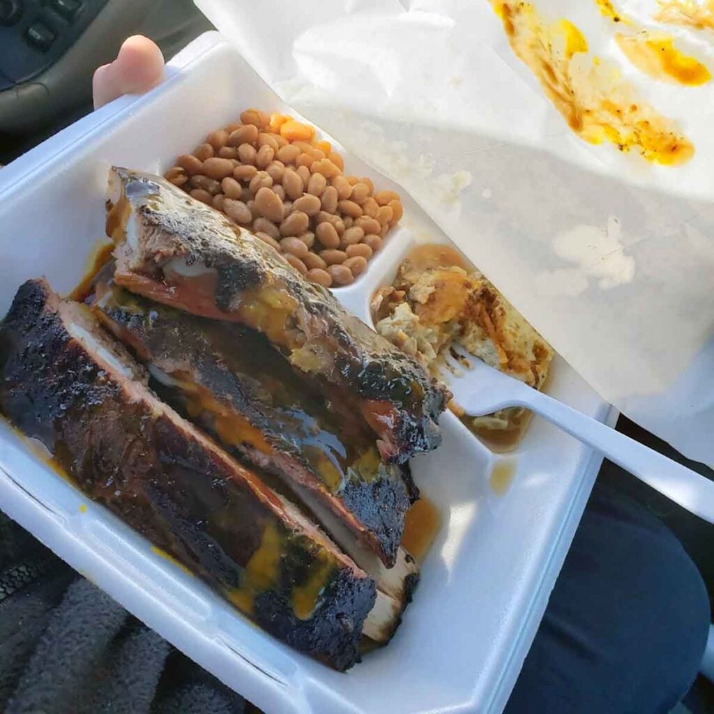Ribs in a to-go tray with sides.