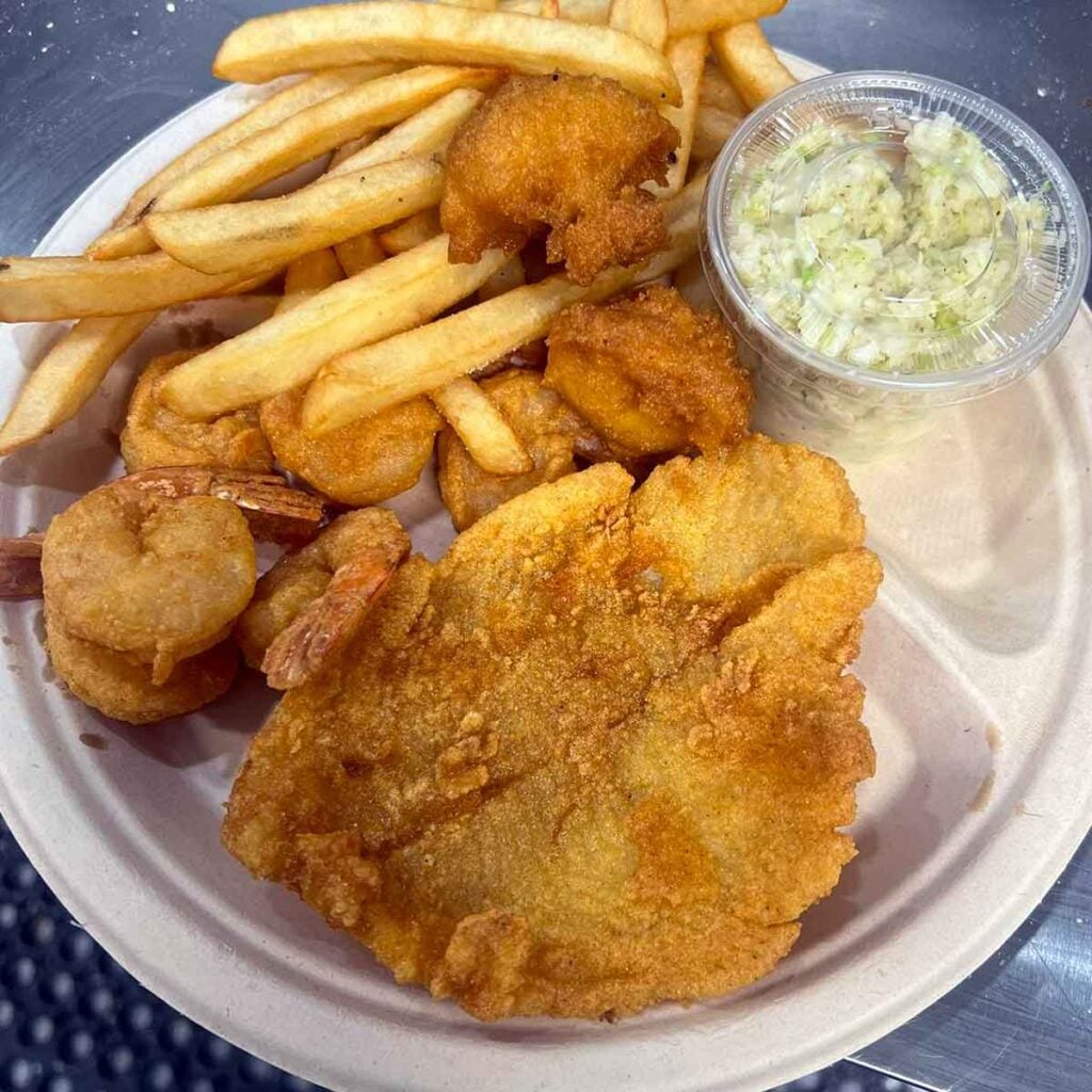 Fried seafood plate with slaw and hushpuppies.