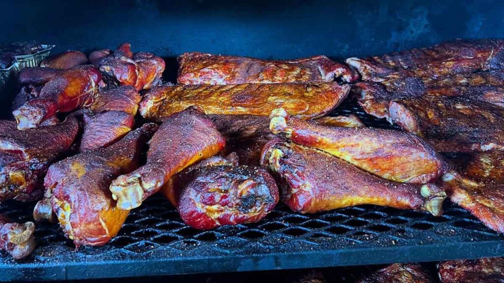 Turkey legs and other smoked meats on smoker.