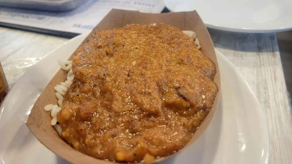 Paper tray filled with hash over rice.