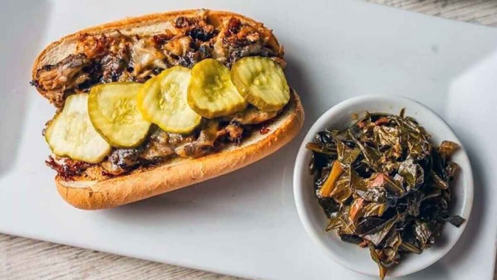 Sandwich with pickles and side of collards.