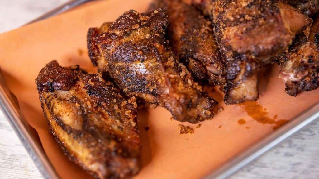 Dry-rubbed wings on a tray with butcher paper.