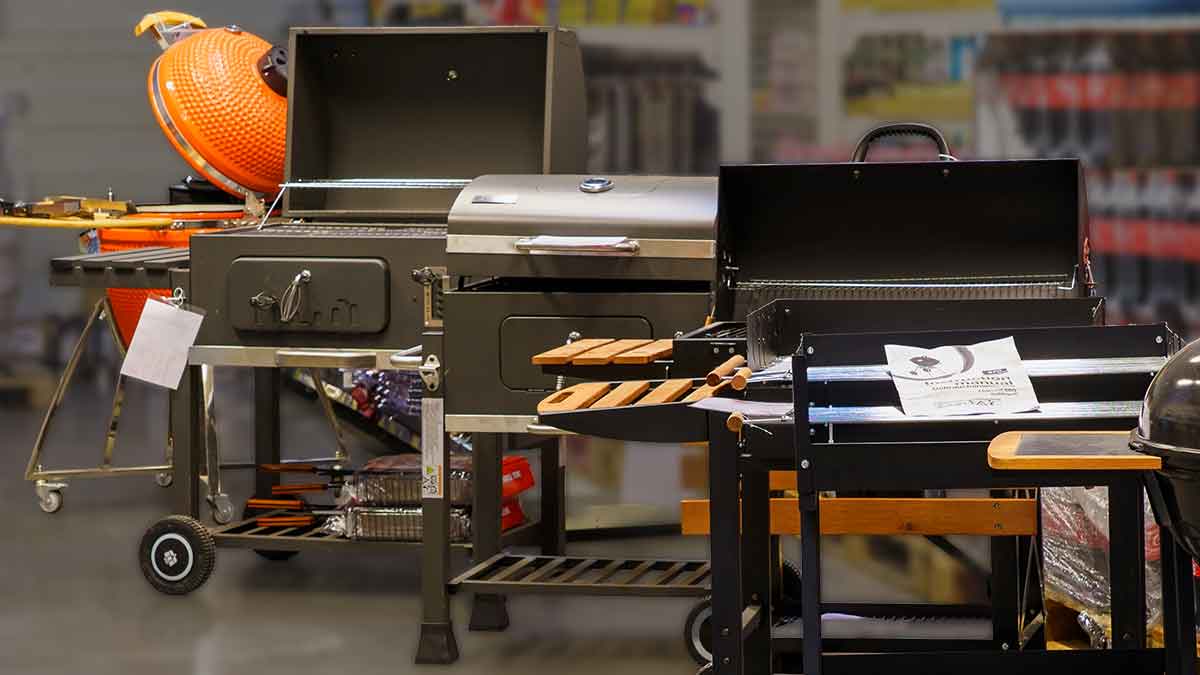 Different styles of grills and smokers displayed together in a store.