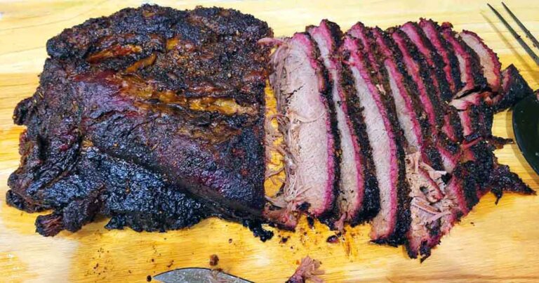 Smoked brisket partly sliced on a cutting board for planning brisket serving portions.