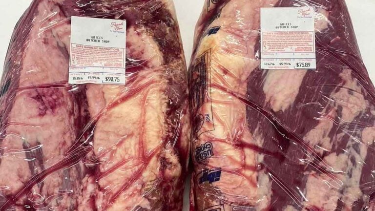 Two whole briskets side by side looking about the same but showing noticeably different prices.