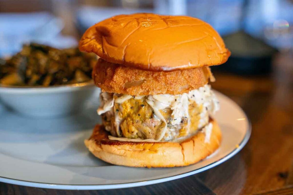 Pulled pork sandwich topped with slaw and a fried onion ring at BearWalrus.