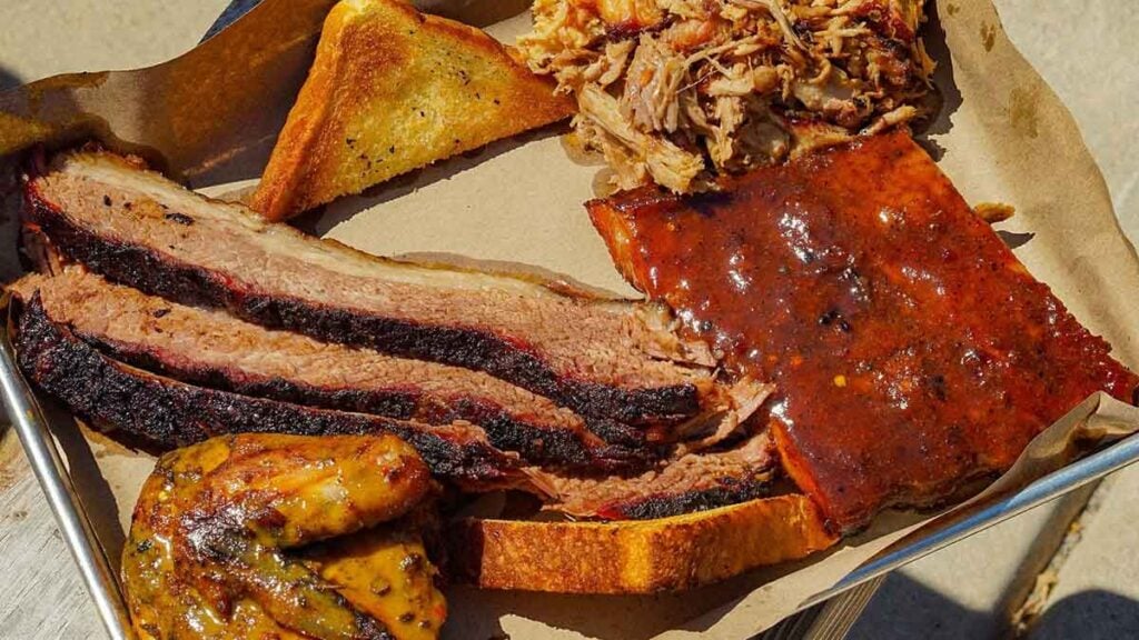 Three meat platter with bread.